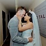 A bride and groom embrace in a hallway, smiling as they dream about the average cost of their destination wedding.