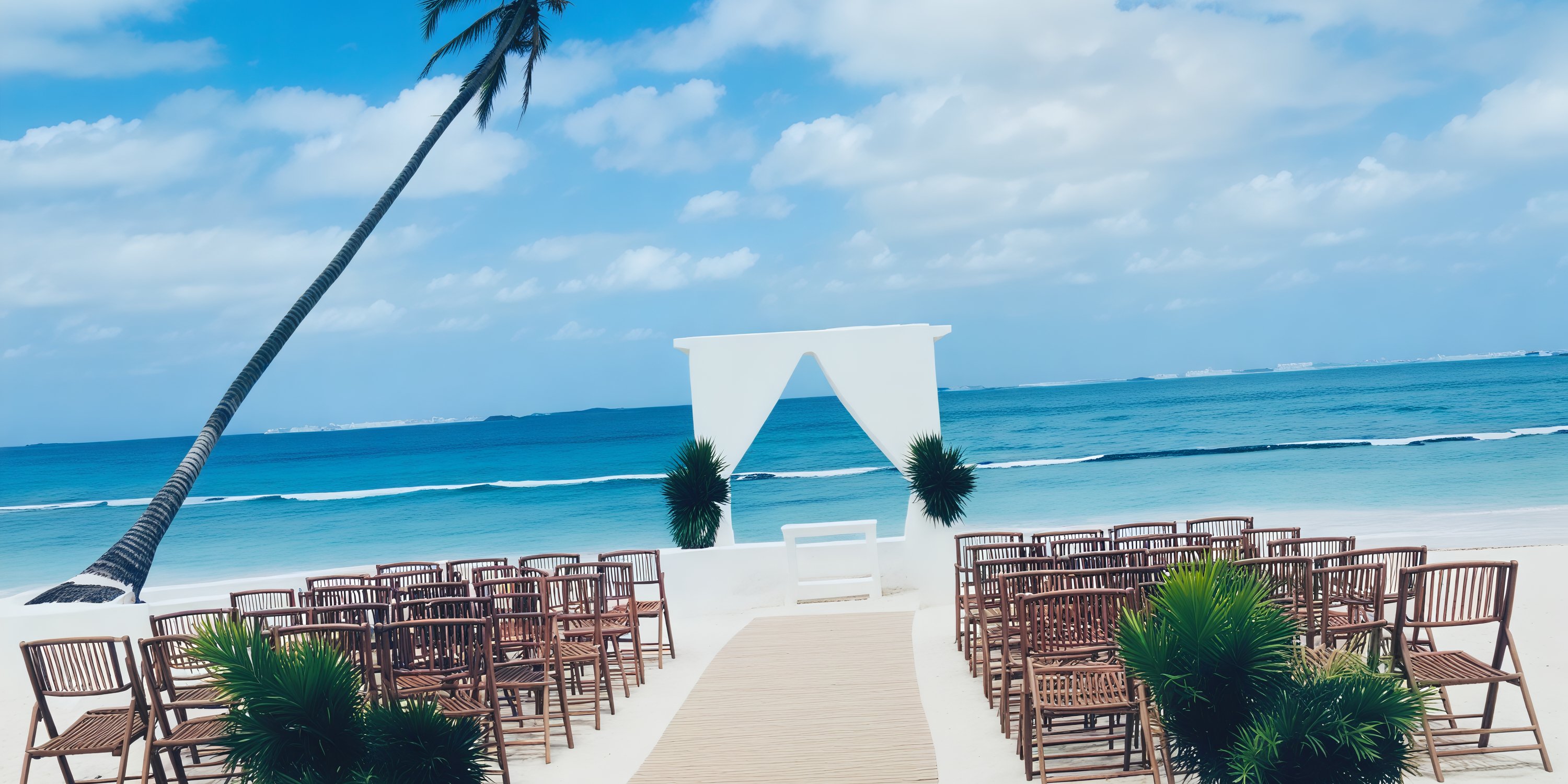 The Dreams Flora destination wedding setup features chairs, an aisle, and a beautifully designed arch set against a backdrop of a cloudy sky.
