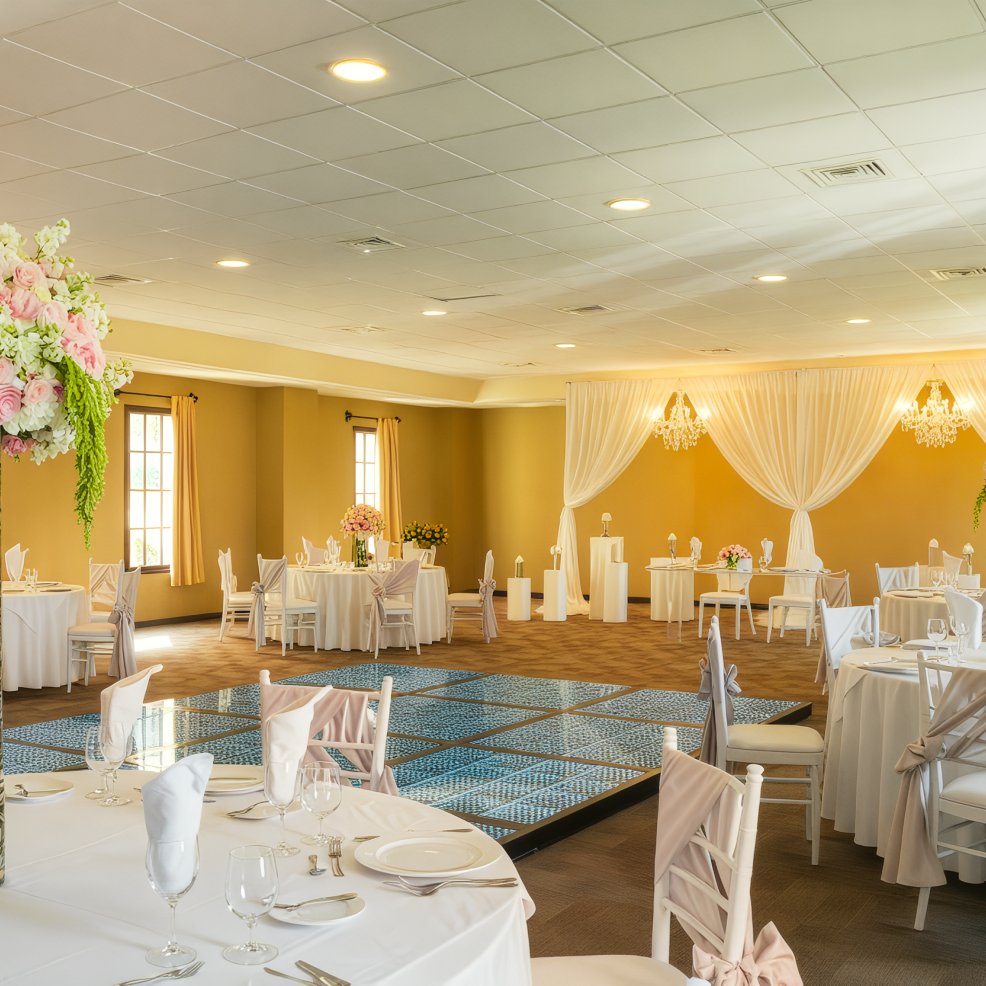 Charming banquet hall for a destination wedding, featuring round tables, white chairs, and a beautifully draped ceiling.