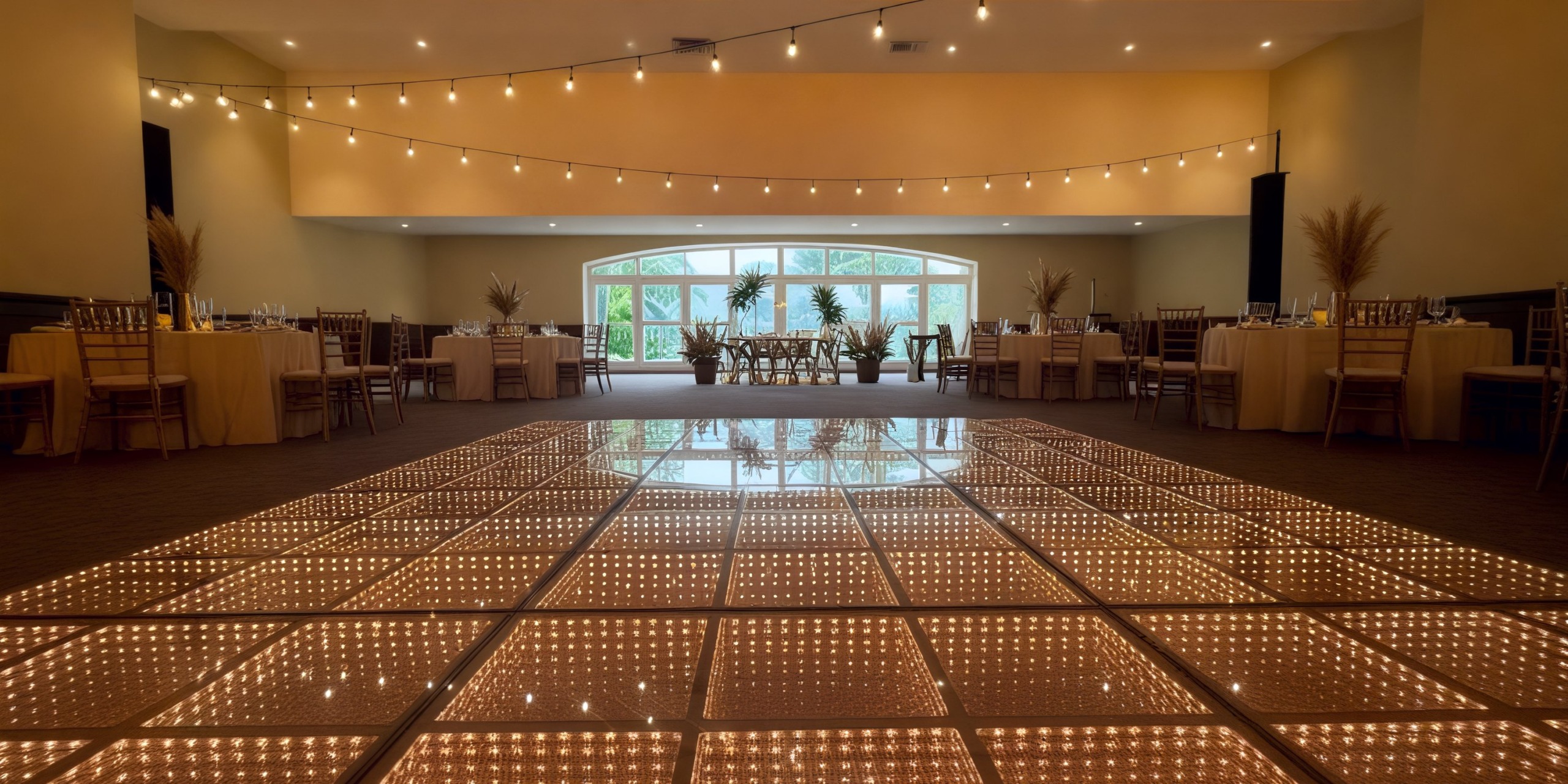 Expansive event hall perfect for a destination wedding, featuring romantic string lights and a beautifully lit dance floor.
