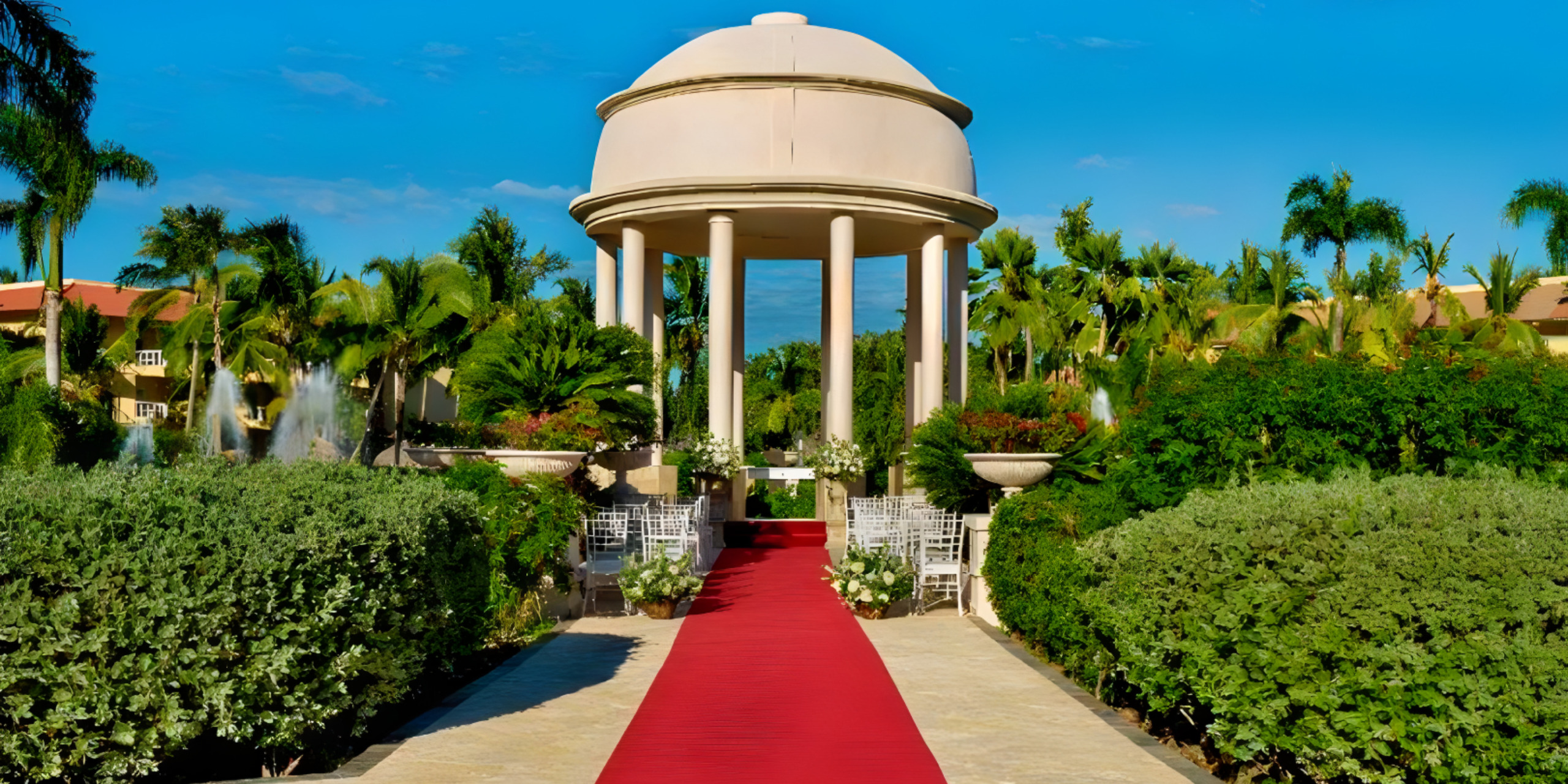A red carpet leads to the entrance of a destination wedding resort.