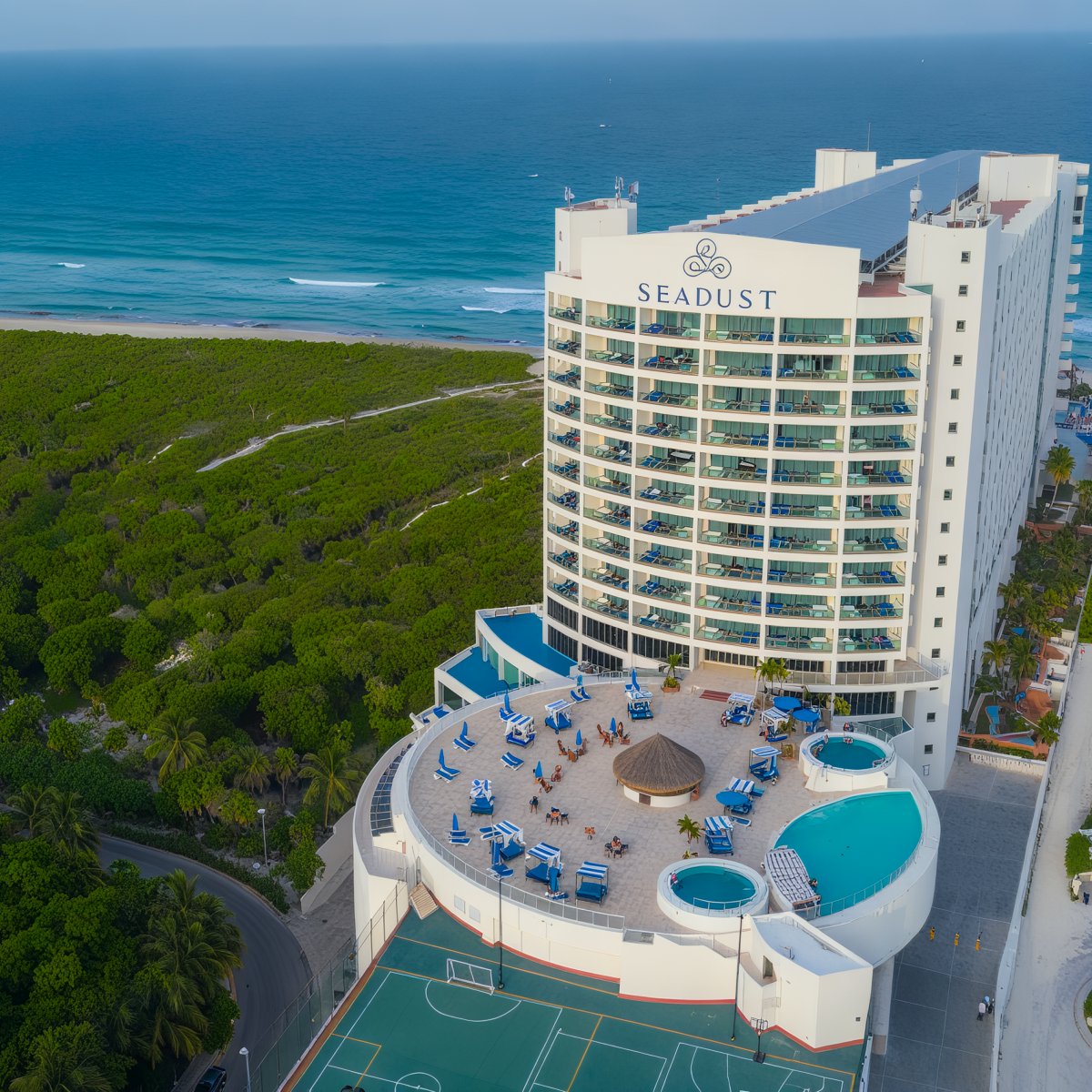 Aerial view of Seadust Cancun, where luxurious pools and scenic courts overlook the ocean, creating the perfect backdrop for a destination wedding.