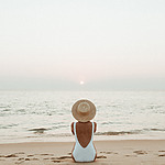 Woman sitting on the beach during destination travel