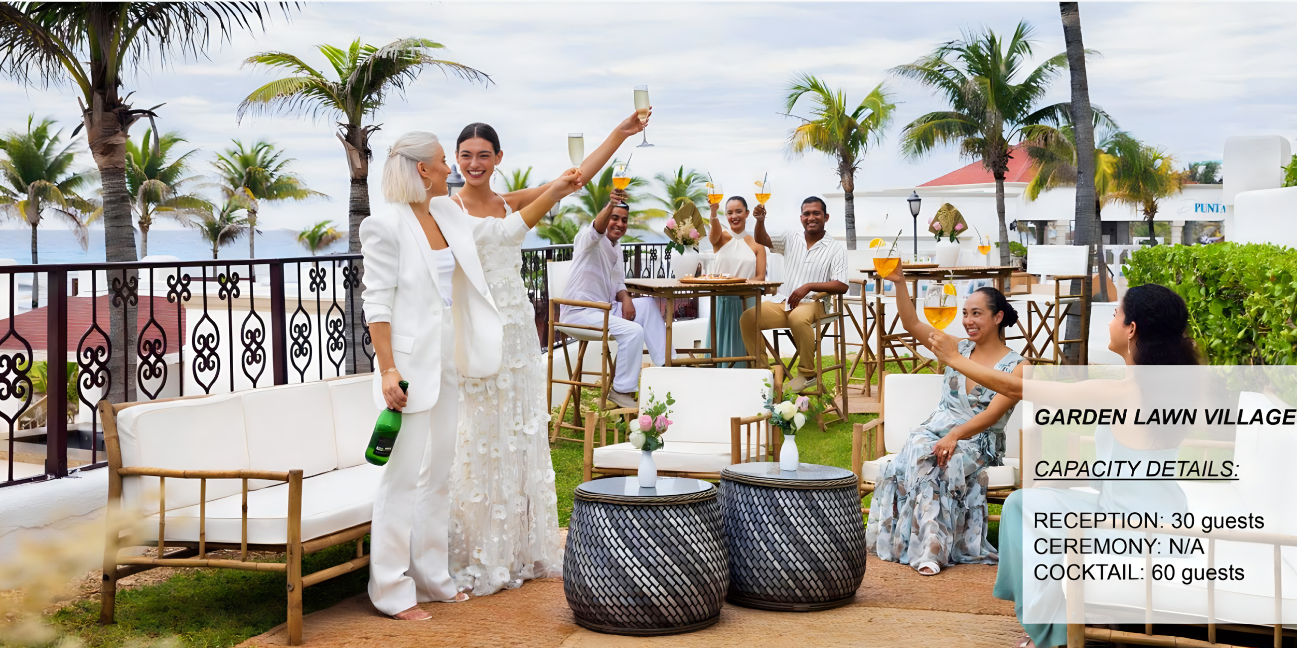 A bride in a white dress opens a champagne bottle at a destination wedding reception on the beach, with guests raising their glasses in celebration.