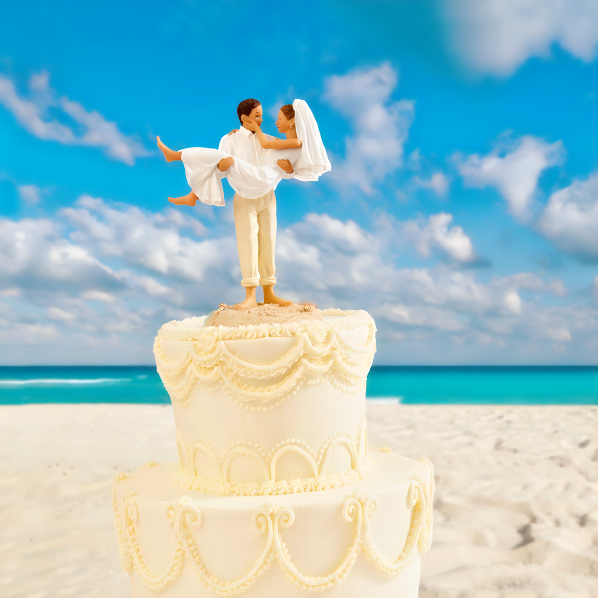 A wedding cake with a couple on top for a Mexico wedding.