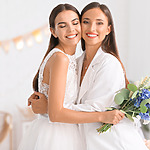 Two bridesmaids hugging each other at a wedding.