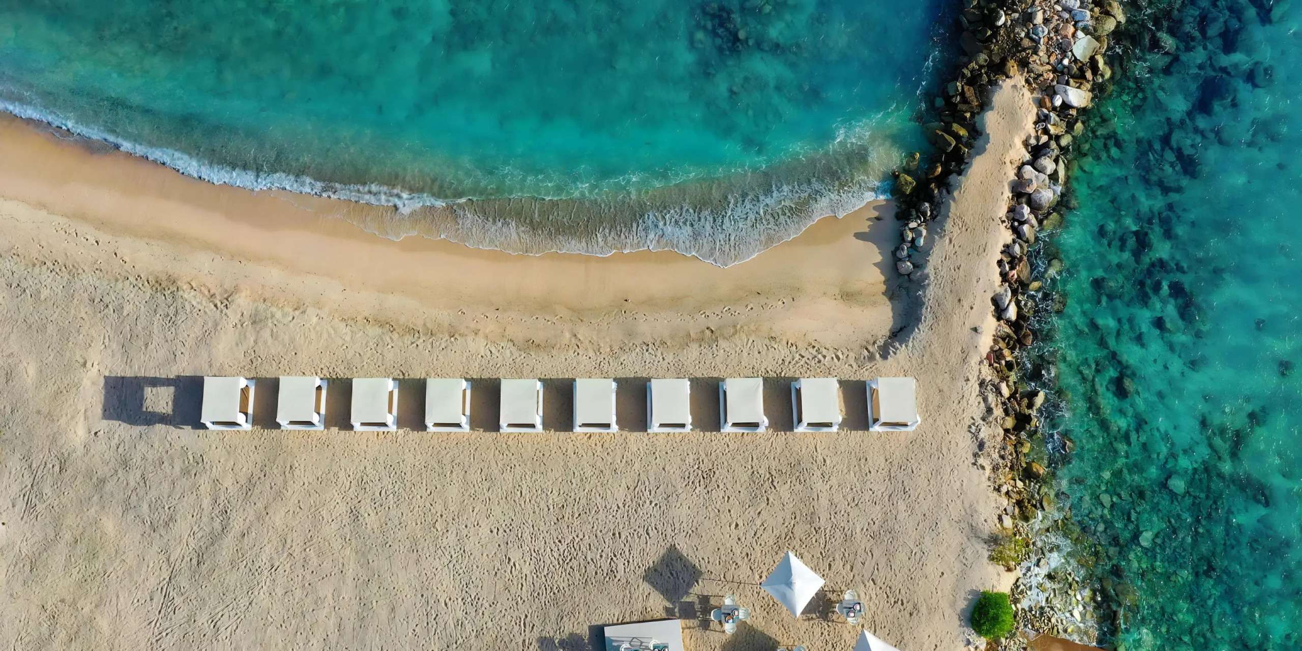 An aerial view of Zoëtry Curaçao Resort & Spa prepared for a wedding with lounge chairs.