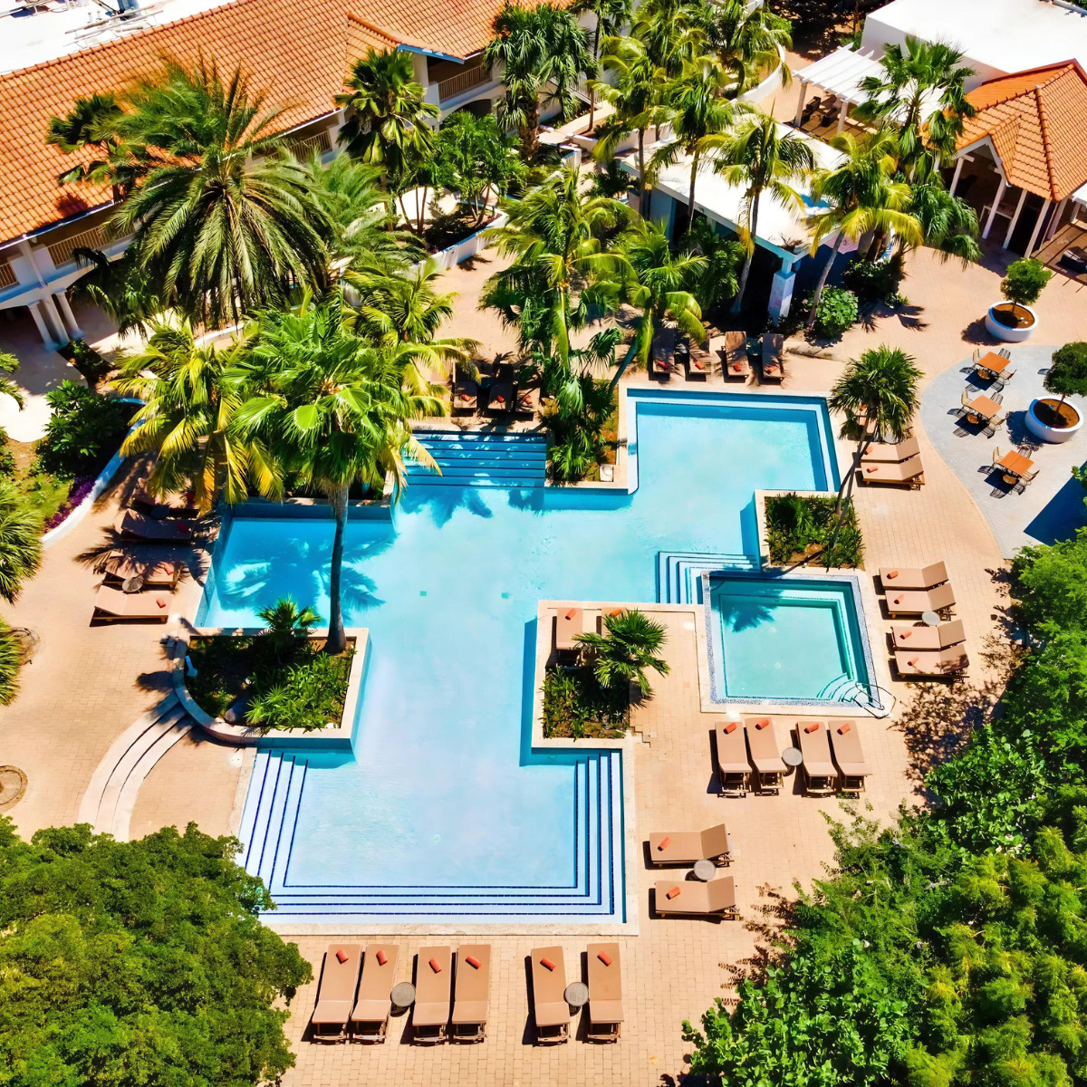 An aerial view of Zoëtry Curaçao Resort & Spa, surrounded by palm trees, prepared for a wedding.