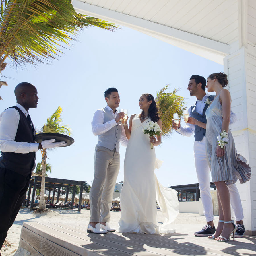 A bride and groom standing on a wooden deck at their wedding.