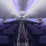 The interior of a plane, designed for a wedding, with purple lights and purple seats.
