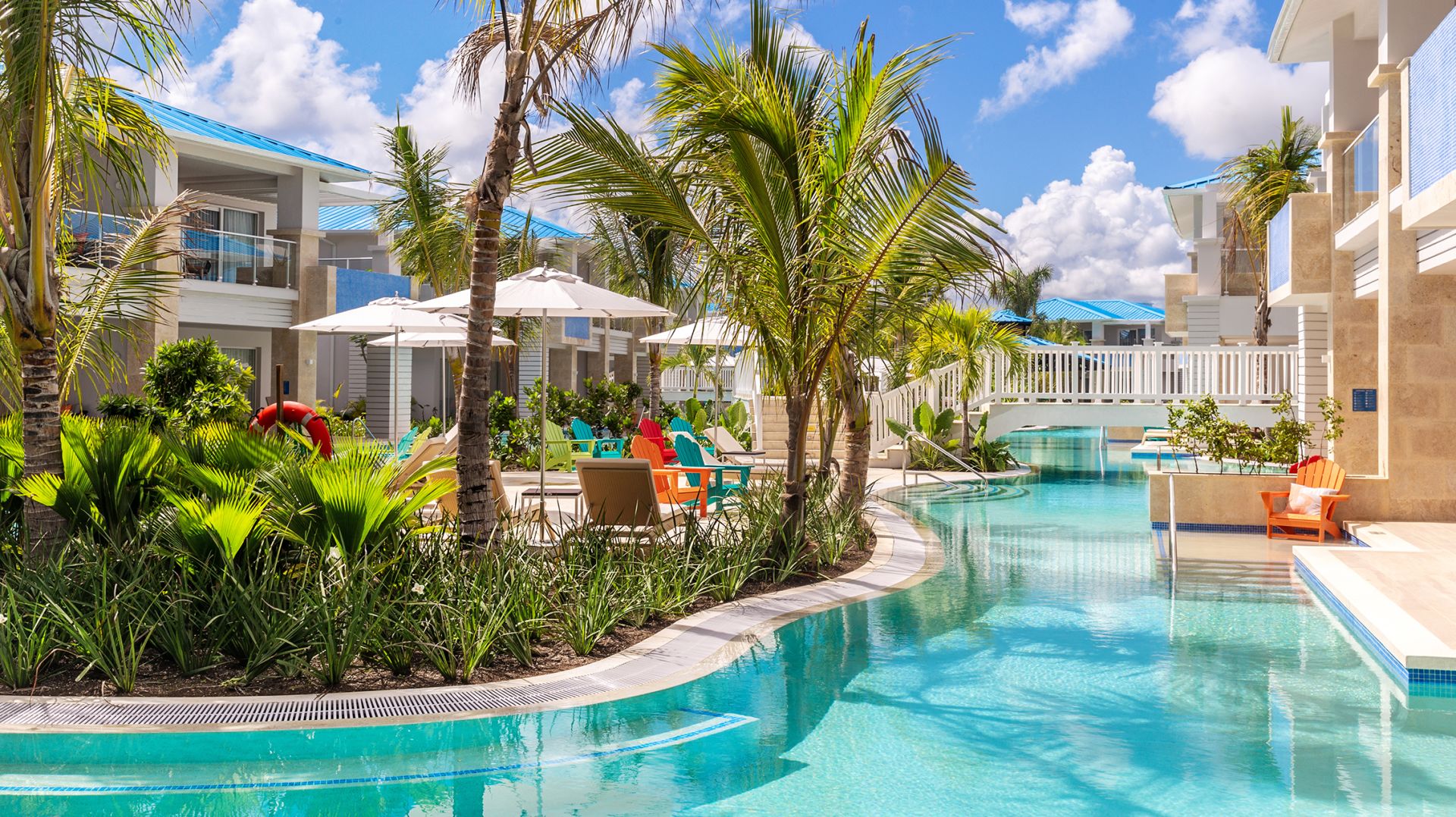 A Margaritaville Island Reserve Cap Cana Wave with a swimming pool, lounge chairs, and palm trees.