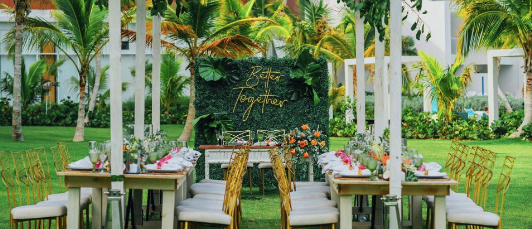 A wedding reception arranged in a grassy area surrounded by Margaritaville Island Reserve Cap Cana - Hammocks.