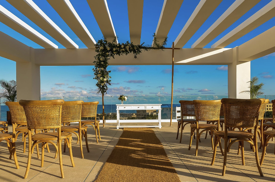 A wedding ceremony set up with Margaritaville Island Reserve Cap Cana - Hammock chairs and a view of the ocean.