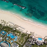 An aerial view of a beach and resort set up for a wedding.