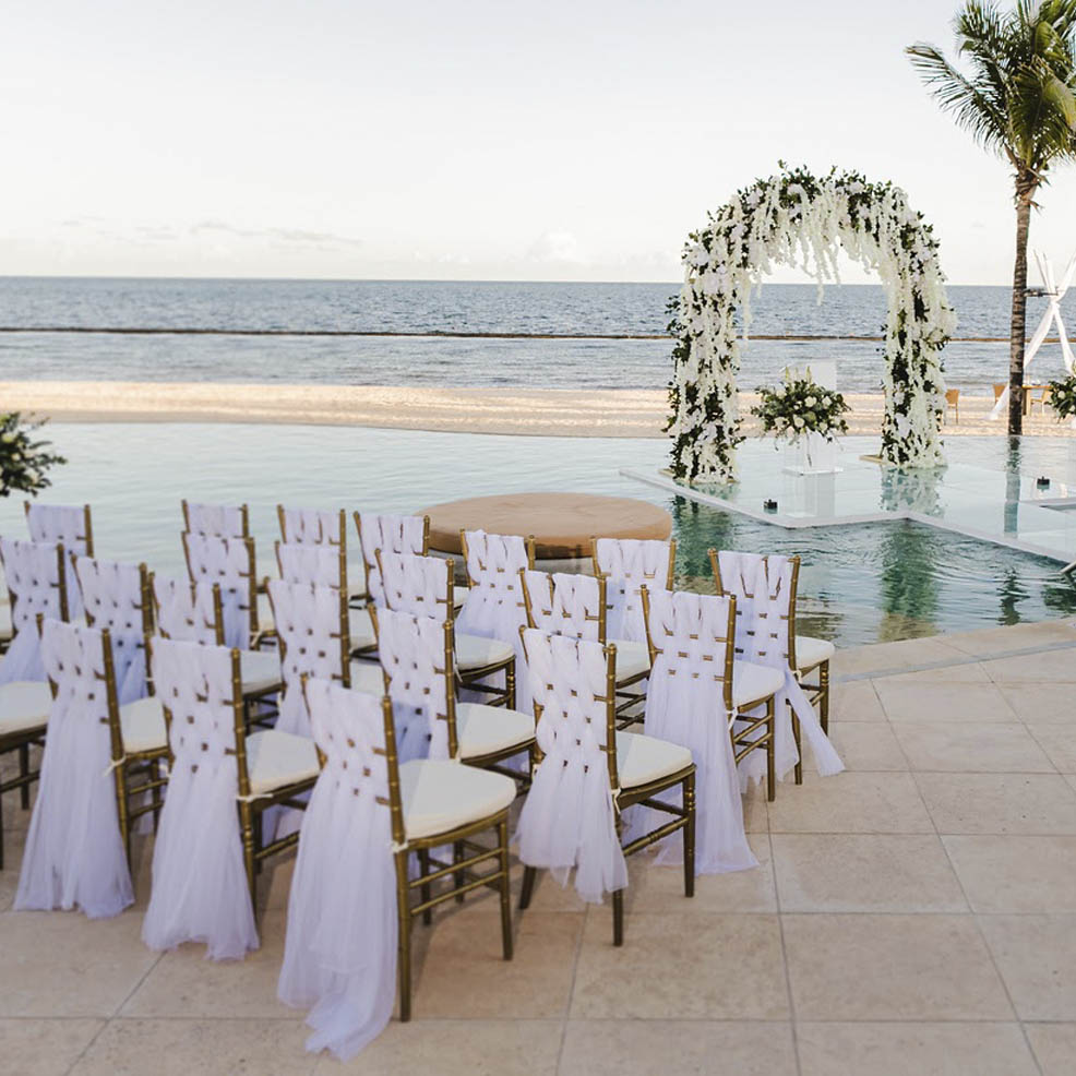 A wedding ceremony set up in front of a pool.