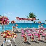 An all-inclusive wedding ceremony set up on a deck overlooking the ocean.