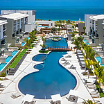 An aerial view of Catalonia Grand Costa Mujeres resort with a pool and lounge chairs.