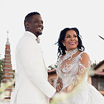 A bride and groom smiling in front of a church, looking as radiant as Blair Underwood.