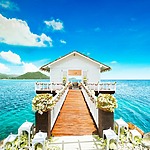 A best destination wedding ceremony on a wooden pier overlooking the ocean.