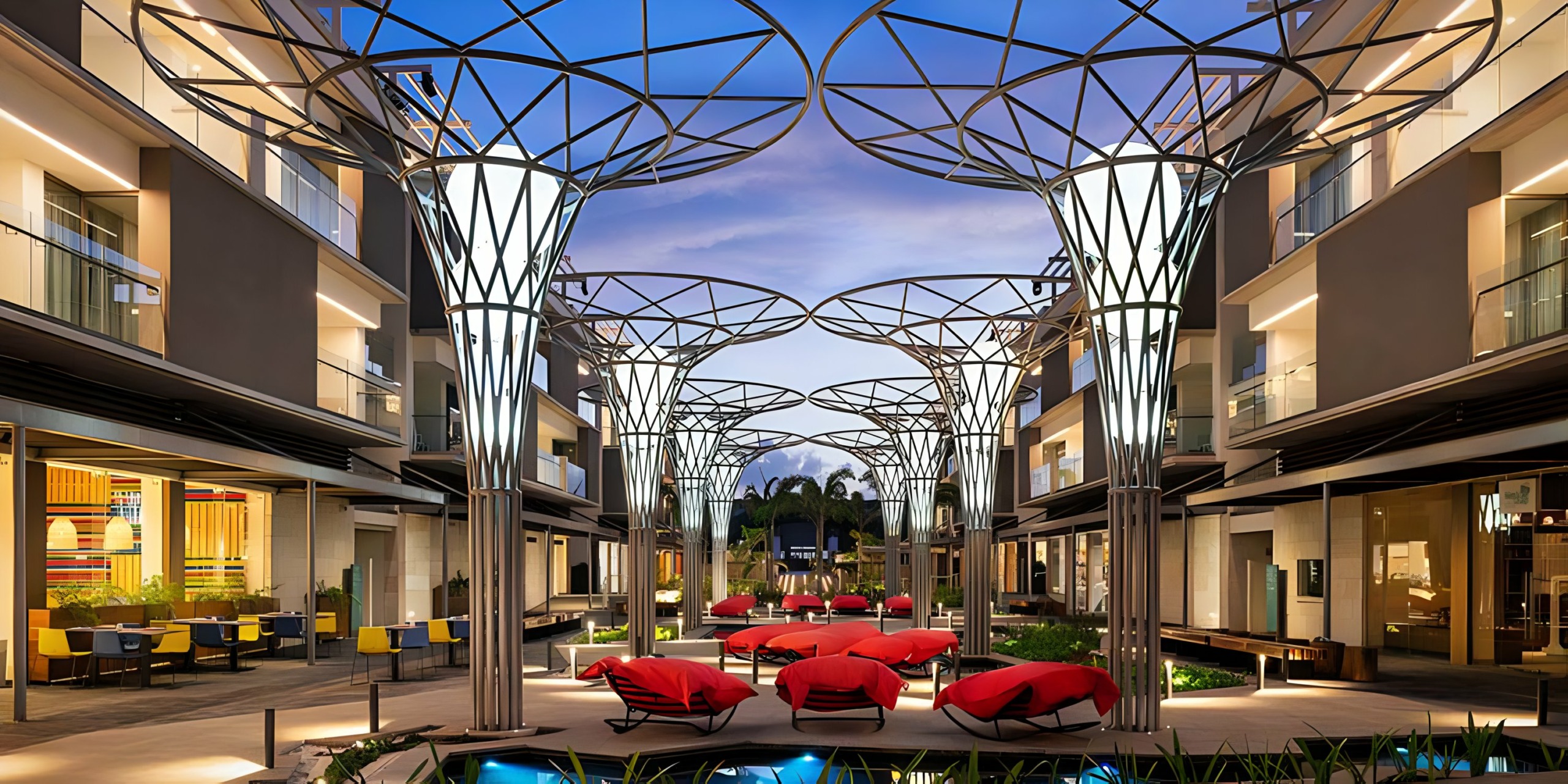 A courtyard with Catalonia Grand Costa Mujeres lounge chairs and a fountain.