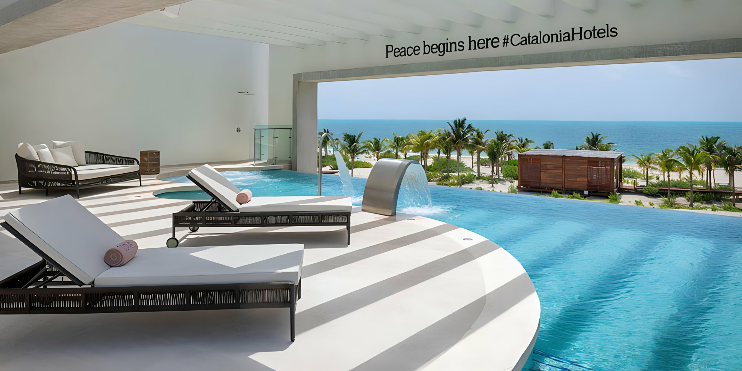 Catalonia Grand Costa Mujeres with lounge chairs and a view of the ocean.