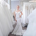 A woman in one of the best wedding dresses standing in a bridal shop.