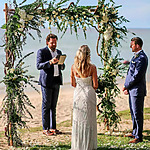 A bride and groom exchange vows under a beach wedding arch officiated by a wedding celebrant.