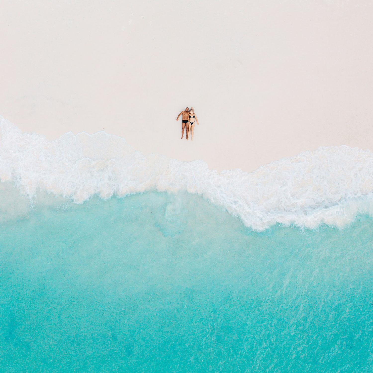 An aerial view of a couple enjoying the beach.