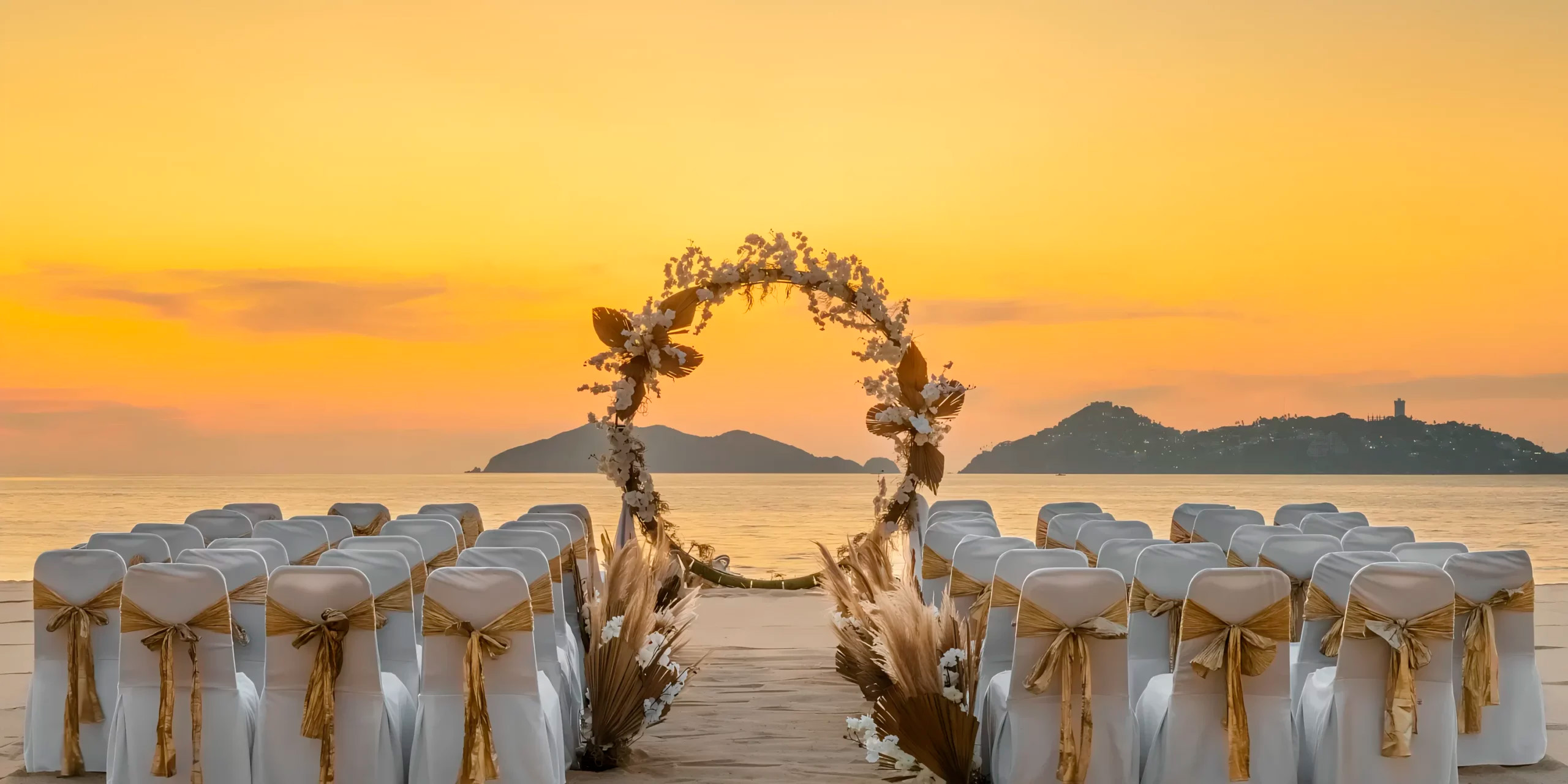 Wedding ceremony arrangement featuring chairs and a floral arch at Dreams Acapulco Resort & Spa, perfect for a destination wedding.