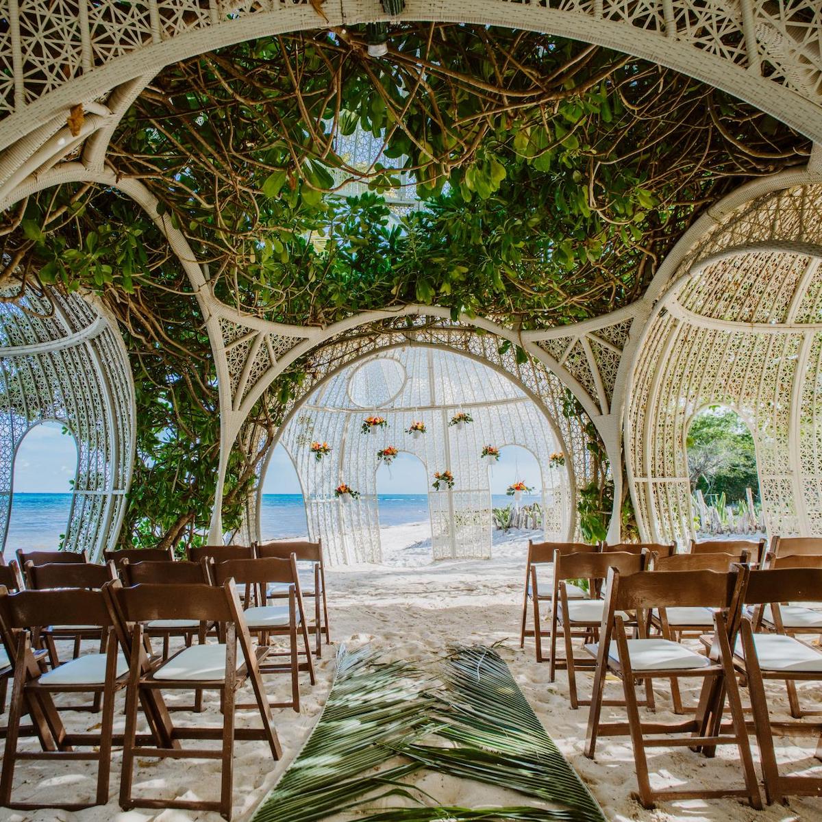 An outdoor wedding ceremony set up on the beach at Sandos Caracol weddings.