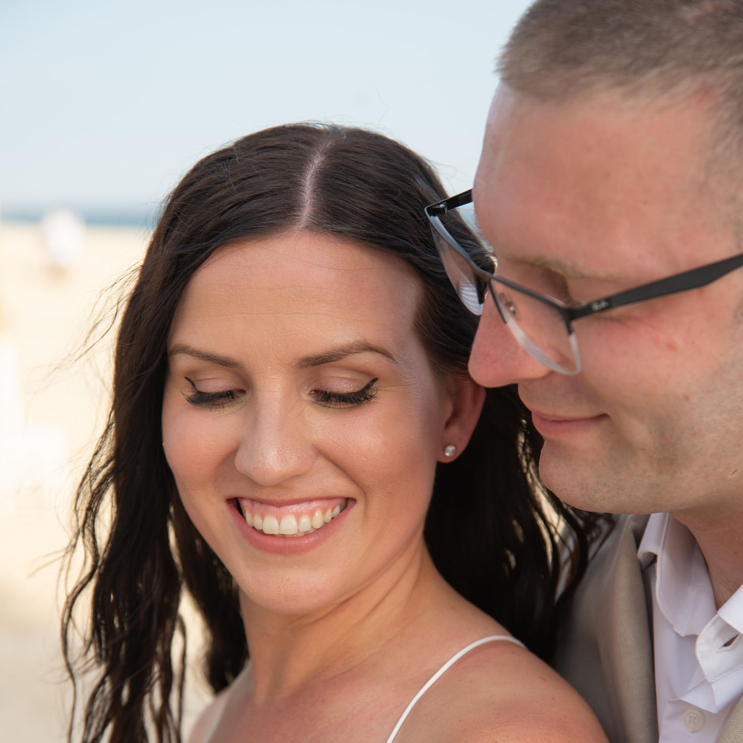 Sarah and Anthony posing for a picture on the beach.