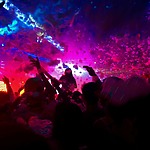A crowd of people at an engagement party with colorful confetti.