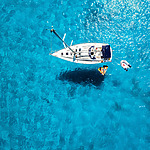 An aerial view of a sailboat in the clear blue water, perfect for weddings.