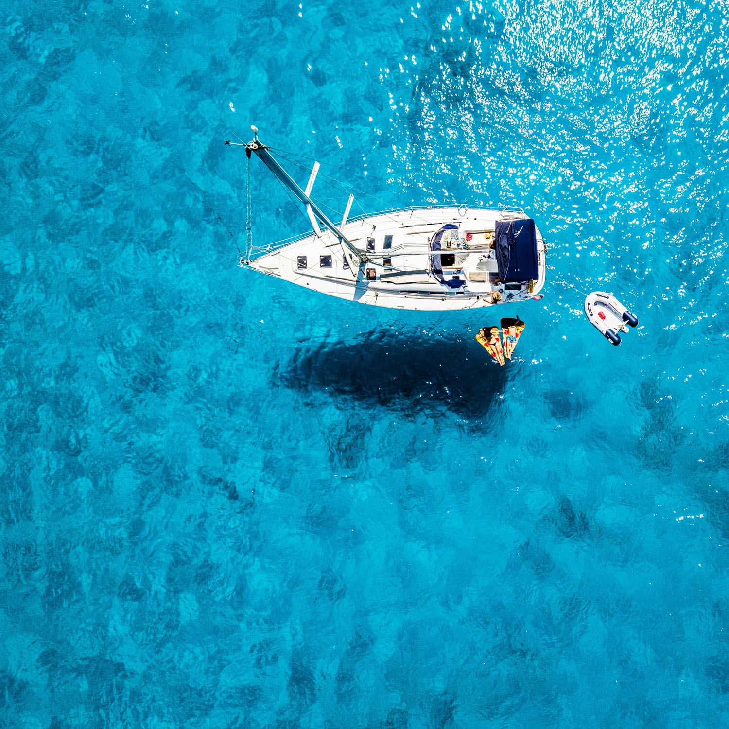 An aerial view of a sailboat in the clear blue water, perfect for weddings.