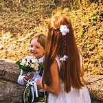 A young boy holds a bouquet of flowers.