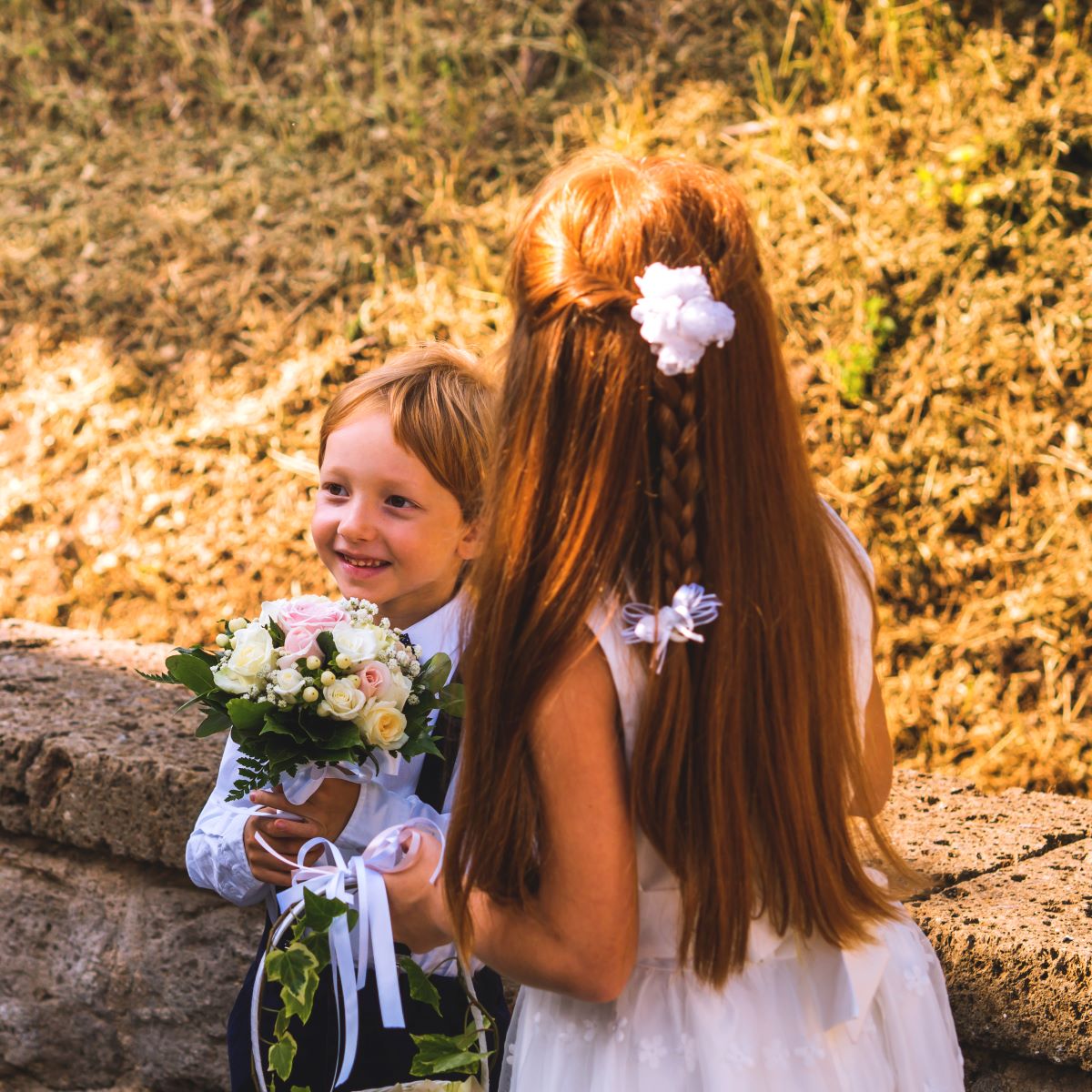 A young boy holds a bouquet of flowers.