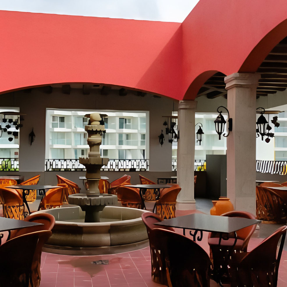 A patio with tables and chairs and a fountain.