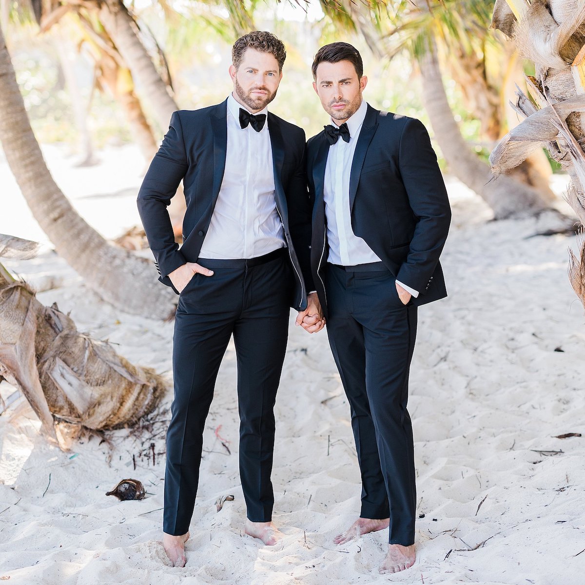 Jonathan Bennett and Jaymes Vaughan, two men in tuxedos, standing on the beach.