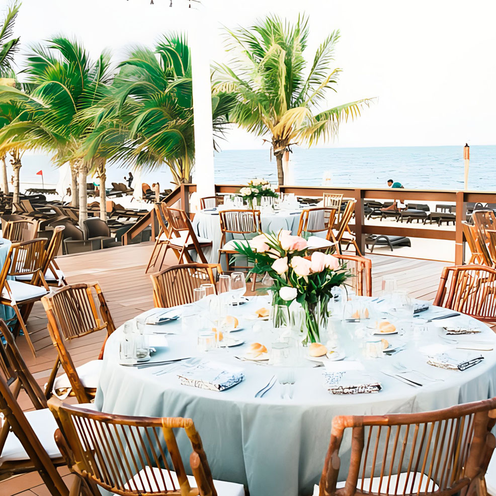 A wedding reception set up on a deck overlooking the ocean.