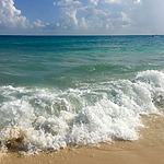 A beach with waves crashing on the sand in Playa del Carmen, ideal for all inclusive wedding packages.