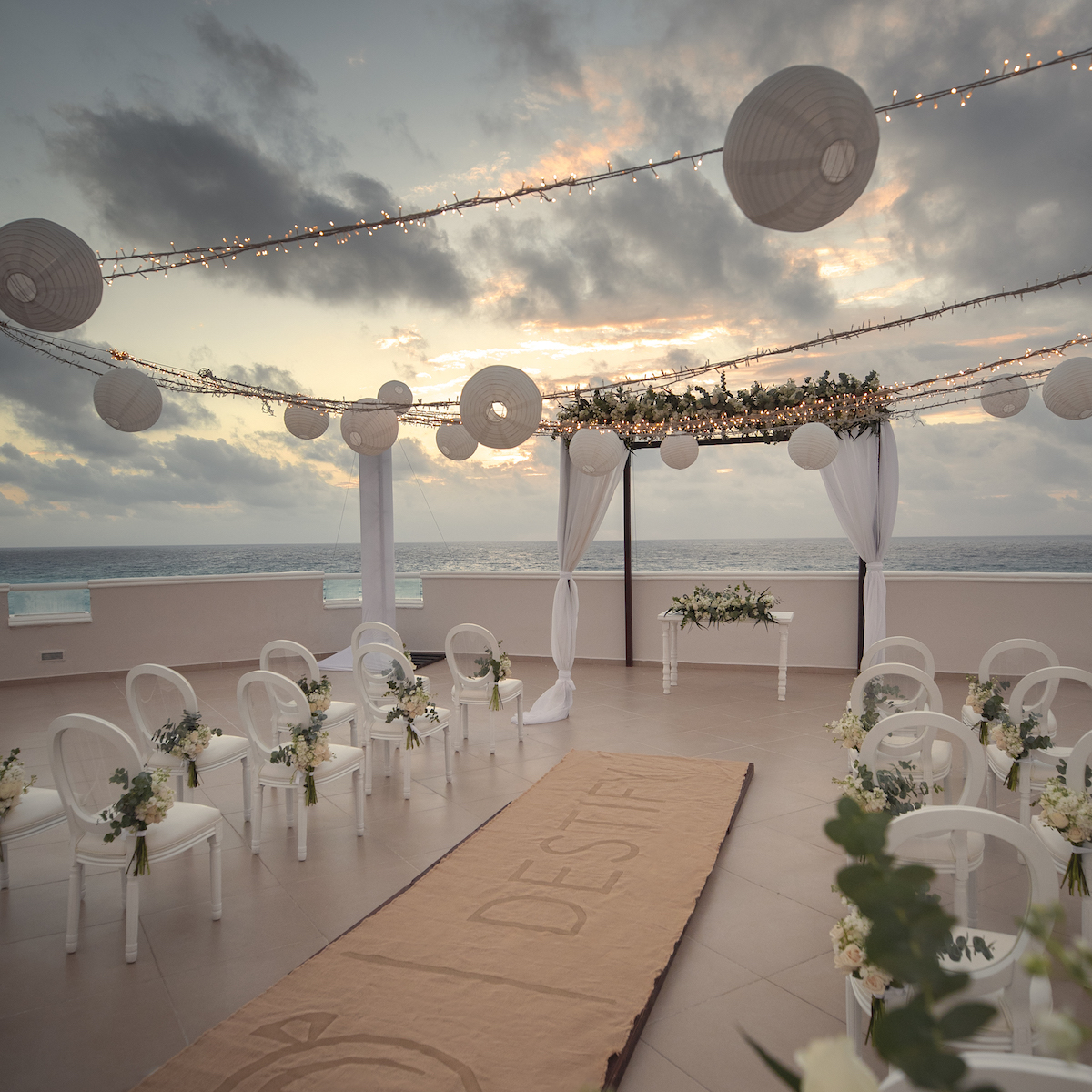 A wedding ceremony set up on a rooftop overlooking the ocean, creating a unique venue for the special day.