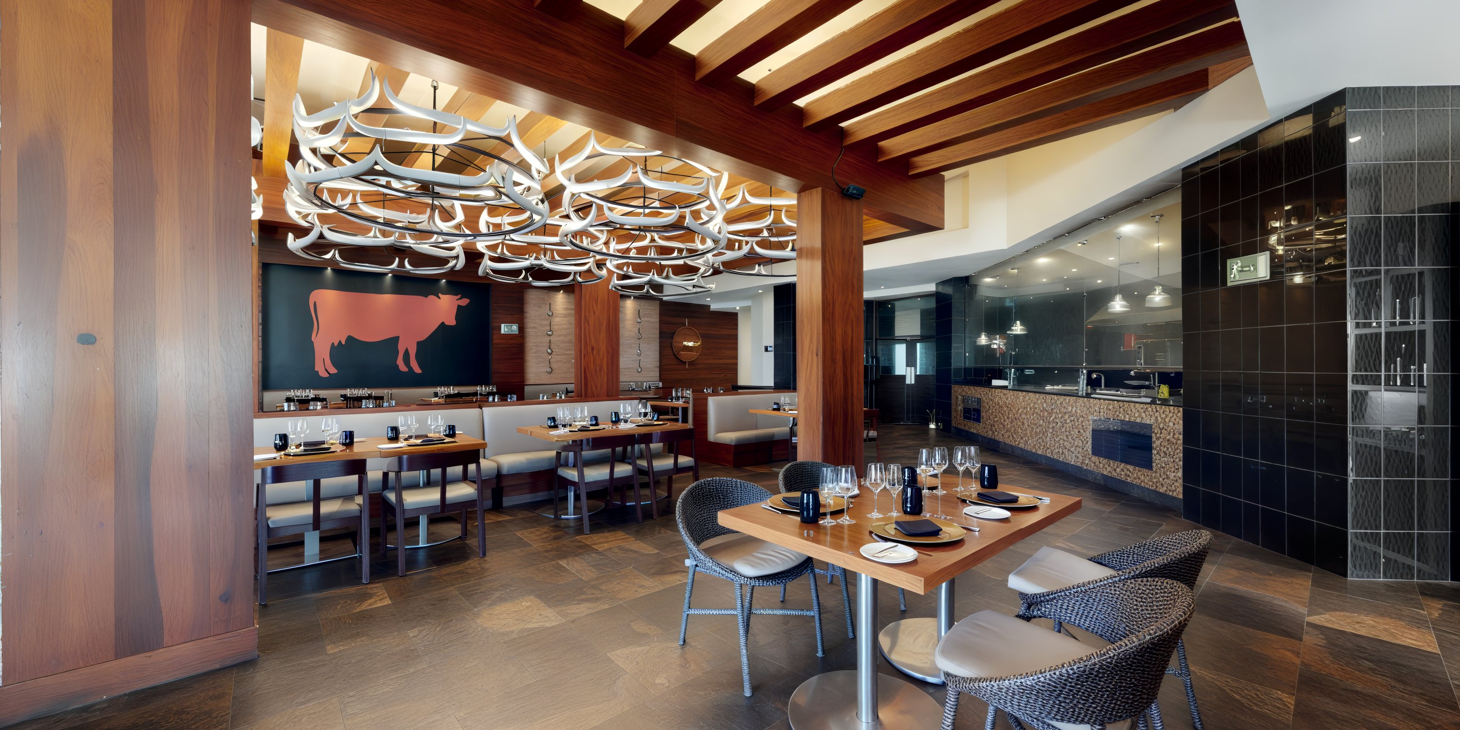 A modern restaurant interior featuring wooden decor and elegant table settings, creating the perfect atmosphere for a destination wedding.
