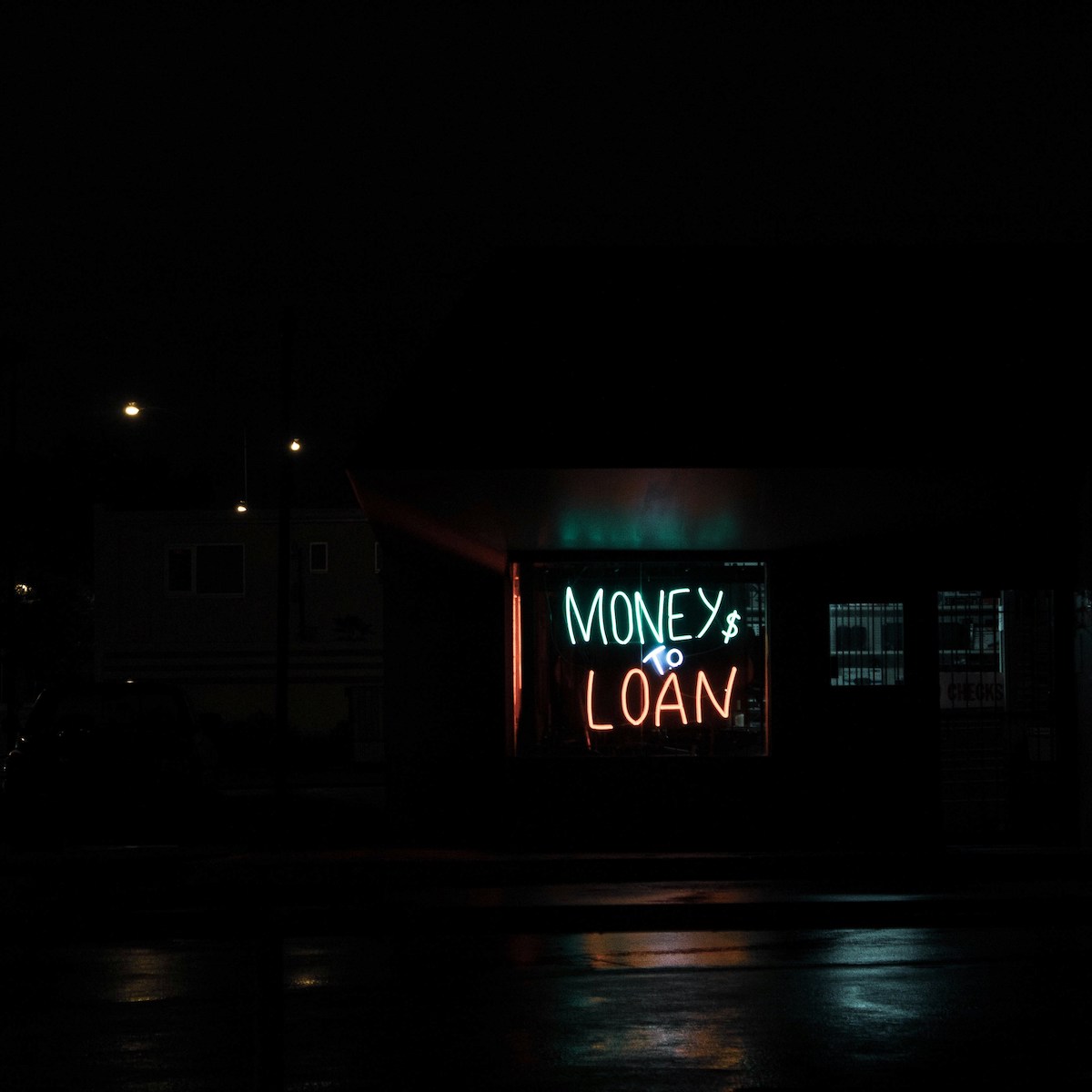 A neon sign that says money and loan at night.