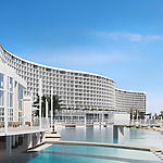 AVA Resort Cancun with a curved facade overlooking a tranquil swimming pool on a clear day.