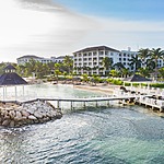 Coastal resort with a pier extending into the sea at sunrise.