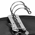 Close-up of a shiny metallic three-ring binder mechanism attached to a black fabric surface, showing the open rings and clasp—ideal for organizing your lists and tips for packing and transporting wedding dresses and suits.