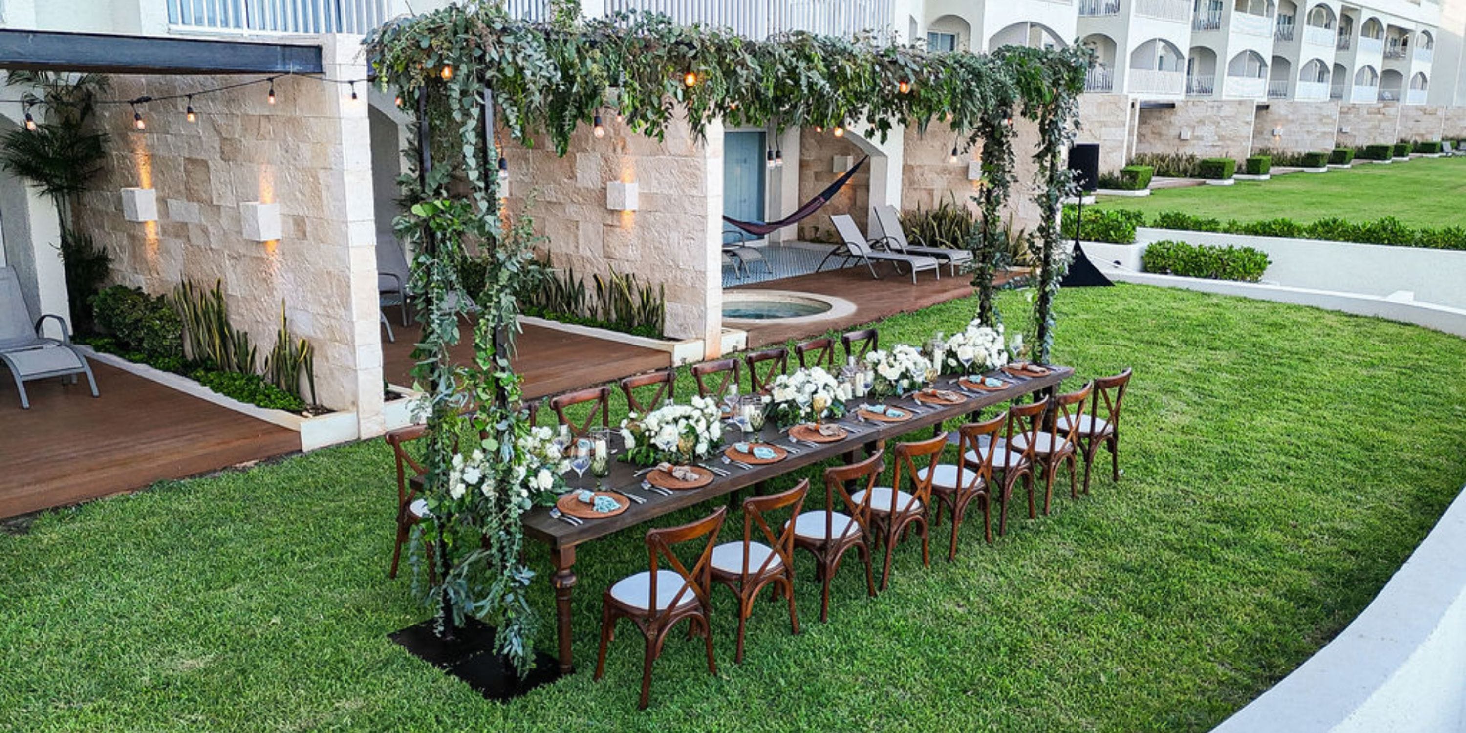 Destination wedding reception setup at Hilton Cancun Mar Caribe, with floral decor under a greenery canopy.