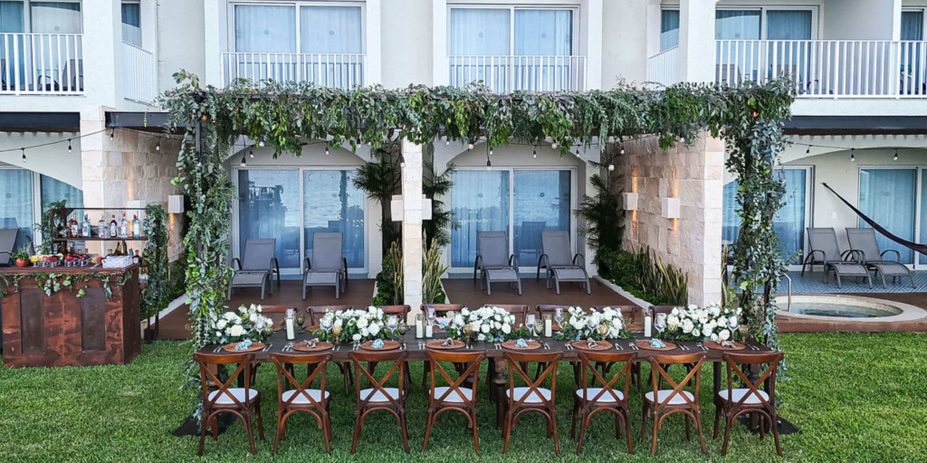 Hilton Cancun Mar Caribe outdoor dining table with wedding floral décor by patio and lounge chairs.