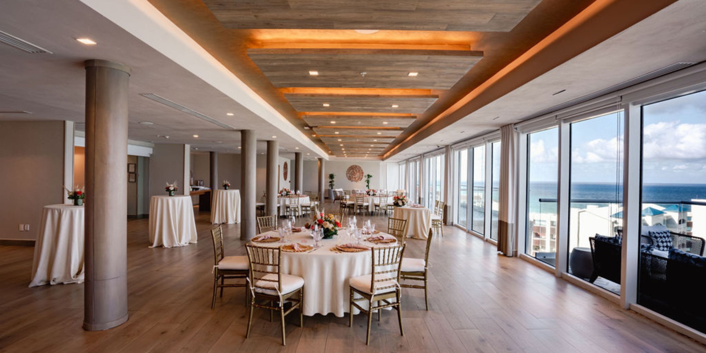 Elegant event space at Hilton Cancun Mar Caribe, ideal for destination weddings, with ocean views and round tables.