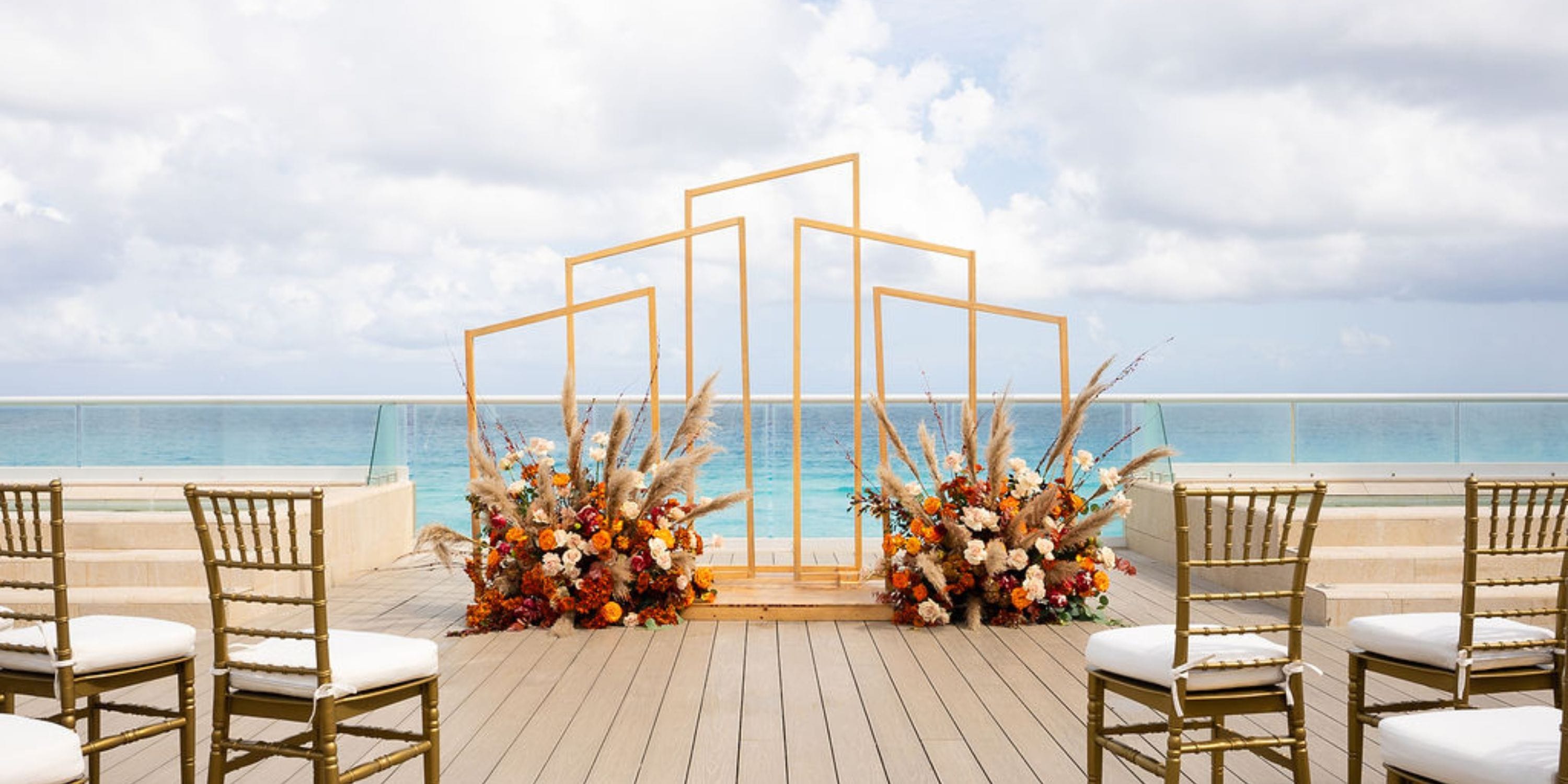 Hilton Cancun Mar Caribe destination wedding with gold chairs, lush florals, and a geometric arch by the sea.